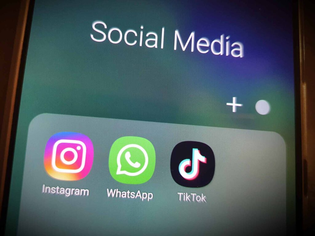 Symbolbild: Foto eines Smartphone-Bildschirms auf dem die Social Media Apps Instagram, WhatsApp und TikTok zu sehen sind.