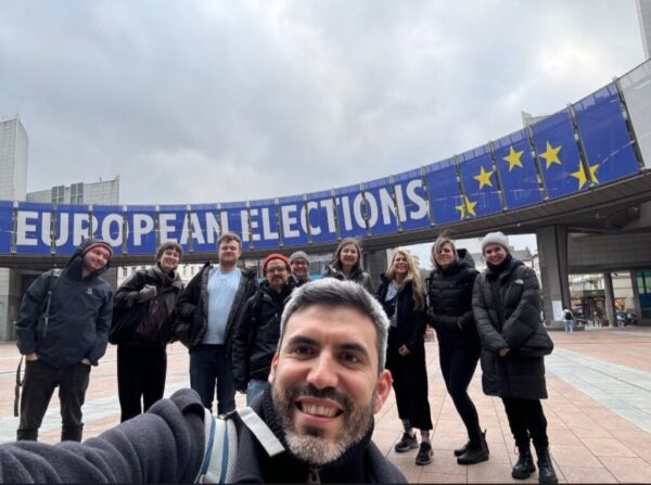 Eine Gruppe Männer und Frauen steht vor dem europäischen Parlament in Brüssel.